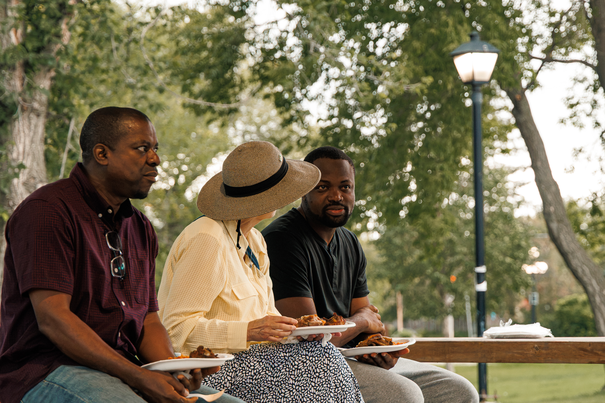 Rotary Club of Brandon members Harrison Ede and Cheryl Winger speaking with Loy Excellentia Picnic Planning Committee member Austin Chukwunta at the 2026 picnic.